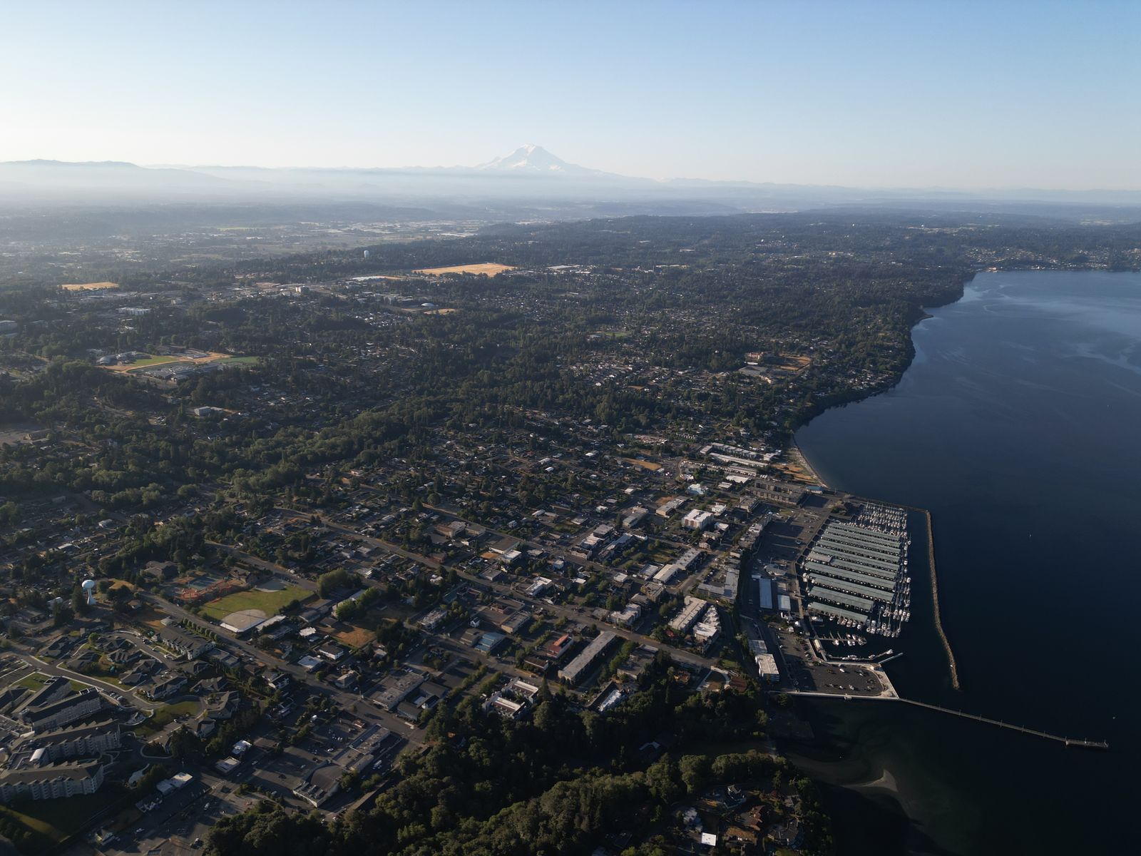 Aerial photograph of the Des Moines shoreline with Mount Rainier faint on the horizon